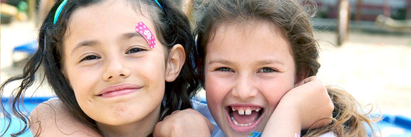 Zwei Mädchen mit Piratoplast Pflaster lachen in die Kamera